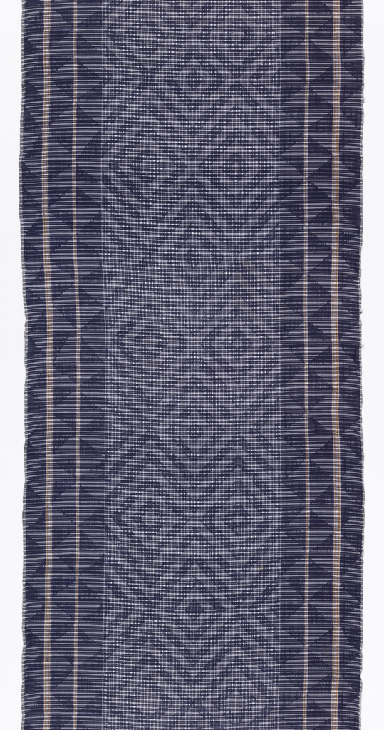 A vertically-oriented textile with a center panel and a wide border on each long side, with geometric forms in shades of blue. The center panel has blue and white check with white threads withdrawn in a pattern of concentric diamonds repeating throughout. The inner diamonds along the center are solid blue, while the remaining are bordered with a lighter shade in the interior. The left and right borders have three blue and white parallel bands that form lines, with the plain weave cloth visible as yellow stripes in between. Each band contains a rotated triangle patterns in dark blue; the effect is almost pinwheel-like.