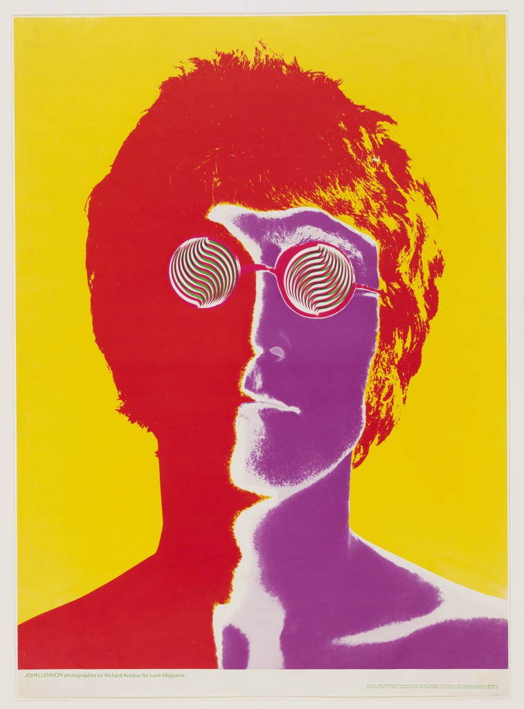 A color saturated, close up image of John Lennon from the neck up. Against a yellow background his face is divided vertically by use of color. The right side is bright purple with white highlights around the edges and the left side which includes his hair is a solid red. The round lenses of his eyeglasses are filled in a dizzying red and white striped swirled pattern.