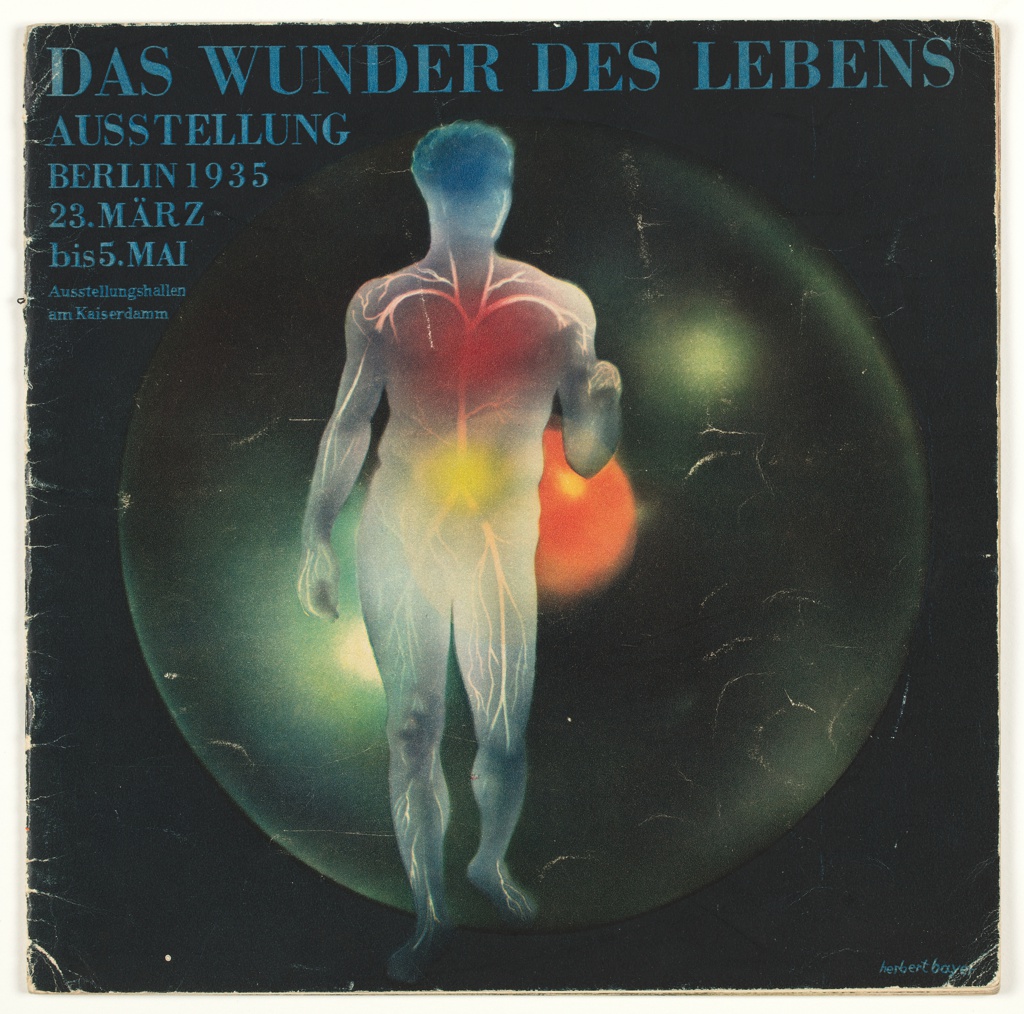 A square black booklet cover features a central figure illustrating the circulatory system of arteries and veins in light gray and white. On the figure, the color blue covers it head, red over its chest, and yellow covers its abdomen. It hovers over an black sphere the same height as the figure. At the center is a smaller red sphere. At the top of the booklet the words 'Das Wunder Des Lebens Ausstellung Berlin 1935' are written.