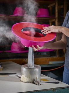 Photograph, Tammy Stief steaming a hat at its final inspection