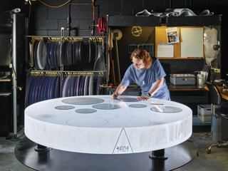 Photograph, Sharlene Carpenter tracing a part template for optimized glass utilization on a boule of Corning High Purity Fused Silica (HPFS) glass