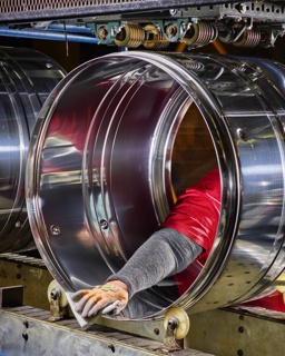 Photograph, Inspecting a stainless steel dryer drum