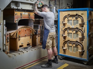 Photograph, John Gonzales molding plywood for the Herman Miller Eames Lounge Chair in a hydraulic press