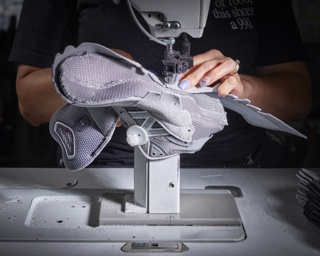 Photograph, Yanet Portes sewing parts of the 990 running shoe upper together