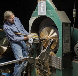 Photograph, Peter Nelson shaping a cymbal on a lathe