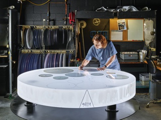 Photograph, Sharlene Carpenter tracing a part template for optimized glass utilization on a boule of Corning High Purity Fused Silica (HPFS) glass