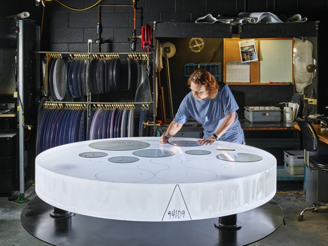 Photograph, Sharlene Carpenter tracing a part template for optimized glass utilization on a boule of Corning High Purity Fused Silica (HPFS) glass