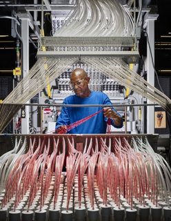 Photograph, Gary L. Boddie gathering yarn to be fed into a carpet tufter