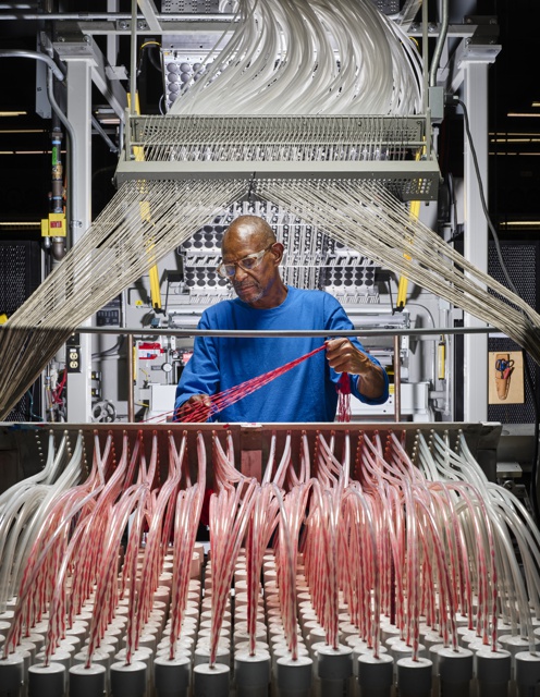 Photograph, Gary L. Boddie gathering yarn to be fed into a carpet tufter