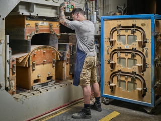 Photograph, John Gonzales molding plywood for the Herman Miller Eames Lounge Chair in a hydraulic press