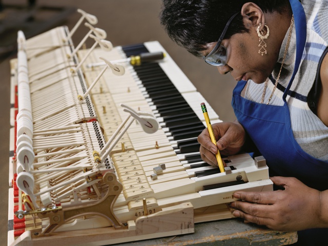 Photograph, Gwendolyn Folk inserts lead weights into the keys to ensure balanced action