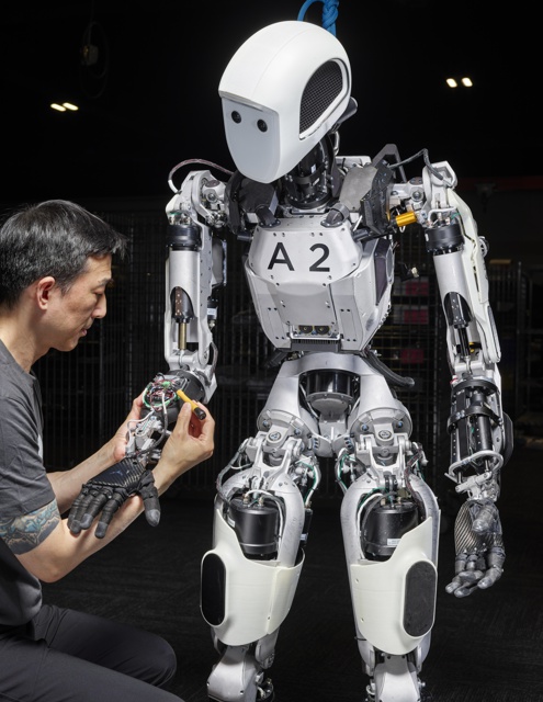 Photograph, Dave Lin installing a motor controller into the arm of Apollo 1™, a humanoid robot