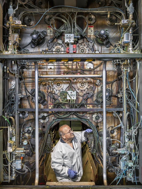Photograph, John Machado, pressman, performing weekly maintenance inside a printing press unit