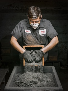 Photograph, Christopher Aparicio unpacking crucibles after heating graphite cores in an oven