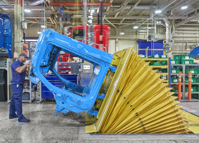 Photograph, Greg Carson installing roof-mounted hardware at the Cab Tilt station