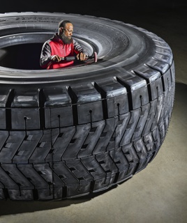 Photograph, Tremonde Gaines polishing a Bridgestone 59/80R63 tire during final inspection
