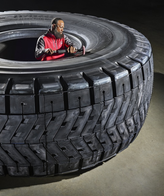 Photograph, Tremonde Gaines polishing a Bridgestone 59/80R63 tire during final inspection