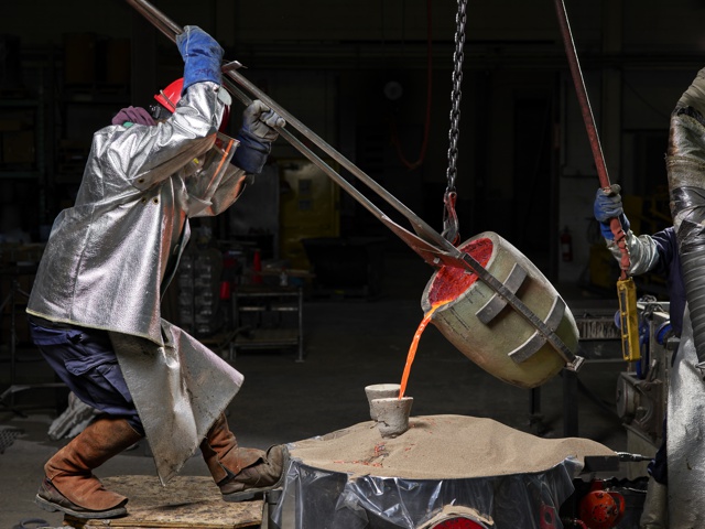 Photograph, Pouring molten bronze into the hollow mold after the wax has been melted out