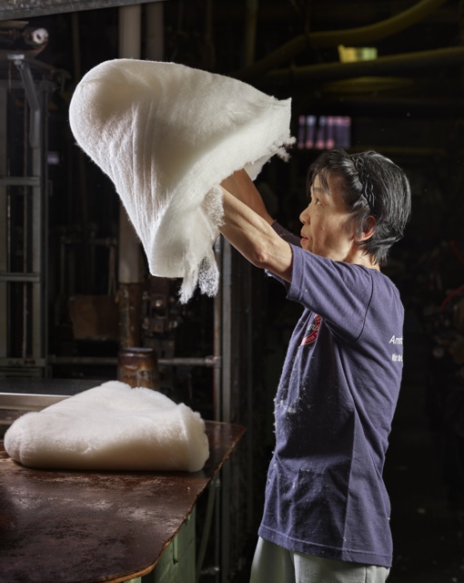 Photograph, Thi V. Phu removing a portion of the wool web to conform with weight specifications of the hat